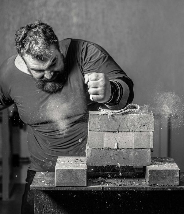 Man performing a powerful strength exercise with golden light accents.