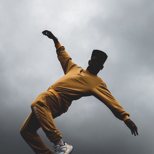 Silhouette of a man in a dynamic movement pose at sunrise.